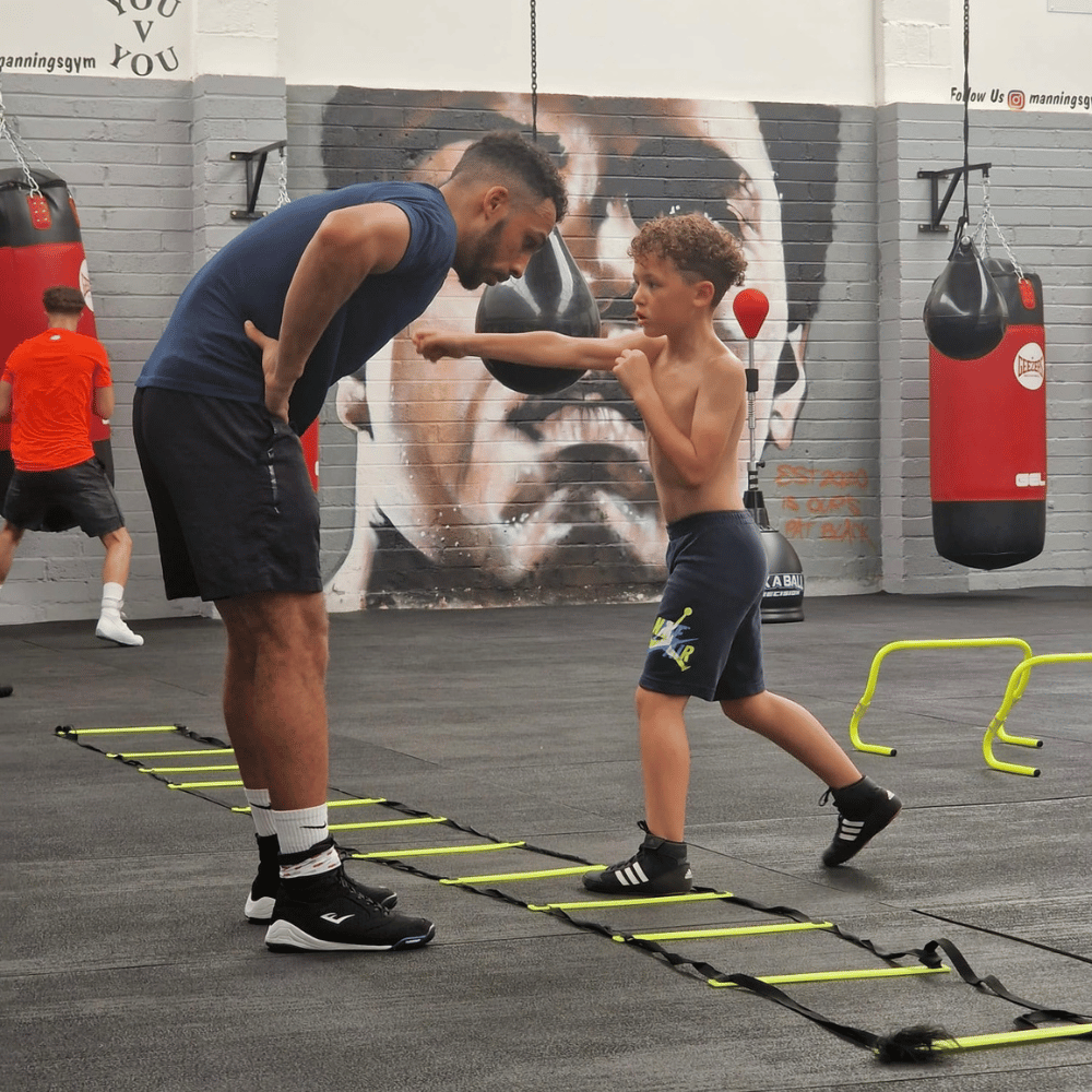 A young boxer practising with a coach