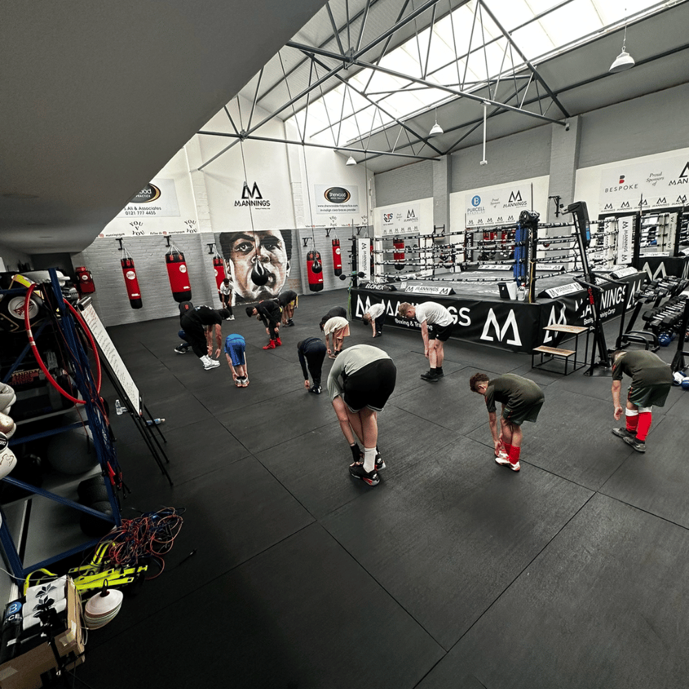 A youth boxing group warming up inside the gym