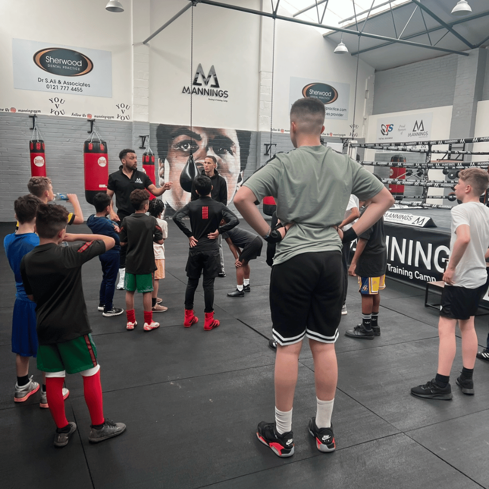 Young people listening to a coach during a boxing session